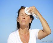 middle aged woman drying sweaty forehead.jpg from sewaty