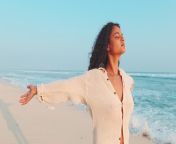 young indian woman spreads arms to sides closes eyes enjoying sea breeze beauty light casual shirt clean air warm 284145453.jpg from indian woman spreads