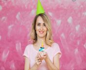 pretty blonde girl birthday cap hold cupcake candle single pink background colorful holiday card 89851338.jpg from cute blonde birthday fingers sl