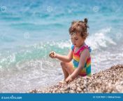 маленькая девочка в красочном купальнике сидит у моря играет на пляже 153379801.jpg from Ð”ÐµÐ²Ð¾Ñ‡ÐºÐ¸ 10 Ð»ÐµÑ‚