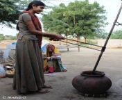 a girl churning buttermilk at lakshman sagar pali rajasthan.jpg from villagers of sagarpali