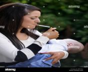 mother in her 20s smoking a cigarette holding and her baby in her brf7rx.jpg from mama cigarette