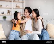 positive pretty young japanese girl mom and dad hugging on sofa have fun enjoy tender moment 2herc9y.jpg from japanese mom and dad son