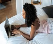 woman bed laptop scaled.jpg fromcom
