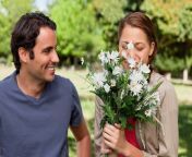 man smiling as he watches his friend smell bunch flowers 13339 43223.jpg from he watches his friend and his wife from the close