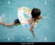 happy indian boy swimming in a pool kid wearing swimming costume along with air tube during hot summer vacations children boy in big swimming pool 2pnx1tm.jpg from no bra wet shirt 🏊‍♀️ swimming pool 🏝 2021
