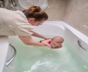 174964726 mom and son are engaged in infant swimming in the home bathroom a woman helps a newborn baby to swim.jpg from mom and son on bath