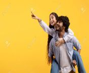 182348671 excited young indian couple having fun and lady piggybacking guy and pointing finger at free space.jpg from desi lovers having fun in public place full