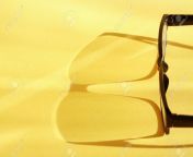 10562739 closeup of spectacles with long shadow on yellow surface nice background.jpg from 10562739 jpg