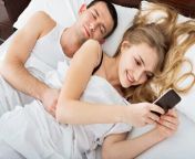cheating woman laying in bed with sleeping husband while texting jpeg from chetar husband