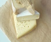 medium hard cheese heads brie parmesan on craft paper pile pieces of different kinds handmade cheese stacked in vertical row on wooden table with cheese fork on top healthy organic eating concept video.jpg from ÐœÐ°ÑˆÐ° cheese 2021 Ð³