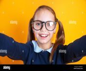 close up of little kid girl 12 13 years old in glasses doing selfie on mobile phone on yellow background 2bbf0k7.jpg from 13 sal ki ladki sel pak sex hindi meww tamanna xxx mp4