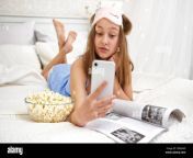 a young girl lies in bed after sleeping and browses social networks on the phone emotion is a surprise free time outside of school quarantine life 2bx0axd.jpg from sleep surprise