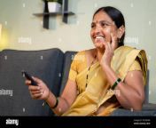 indian woman in saree watching tv at home while sitting on sofa by holding remote during leisure time 2ecndak.jpg from aunty remote image