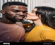 beautiful woman moves to kiss the face of a cool black guy looking at the camera 2ew5ck7.jpg from beautyful kissing