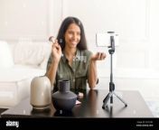charming glamorous indian woman beauty vlogger doing makeup in front of smartphone on the tripod and sharing on social media streaming live video tutorial online influencer girl recording content 2g7cy8c.jpg from indian live video beauty