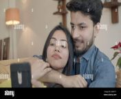 a young indian couple watching videos together while lying on the sofa at home 2g8a111.jpg from desi couple new videos