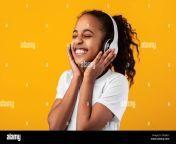 smiling young black girl listening to music in headset 2f5xa2y.jpg from ebony listening