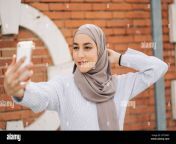 young smiling muslim female in traditional hijab standing on street and taking self shot on smartphone 2f750wy.jpg from hijabi gf selfshot video getting naked for bf
