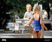 a happy little boy and nice girl in a blue swimsuit plays with a water tap in a city park special water equipment for childrens games on a hot summe 2j8mheb.jpg from sexy childen gir