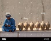 omani man reading his mobile phone sit next to potteries ad dakhiliyah region nizwa oman mt98b9.jpg from omani mobil
