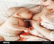 closeup portrait of young beautiful caucasian mother breastfeeding baby lying together in bed on one side peay6f.jpg from breastfeeding beautiful mom