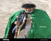 old sufi man wearing green coat walking in the desert with stick towards hashish smoking den old balkh north afghanistan r0t0k1.jpg from old man muslim long hair student teachers and